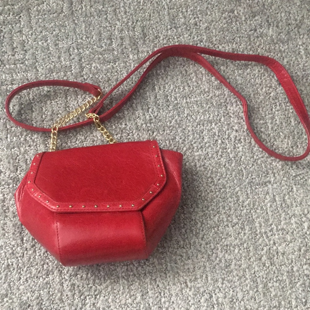 A lovely red crossbody bag with gold design, and flower design inside